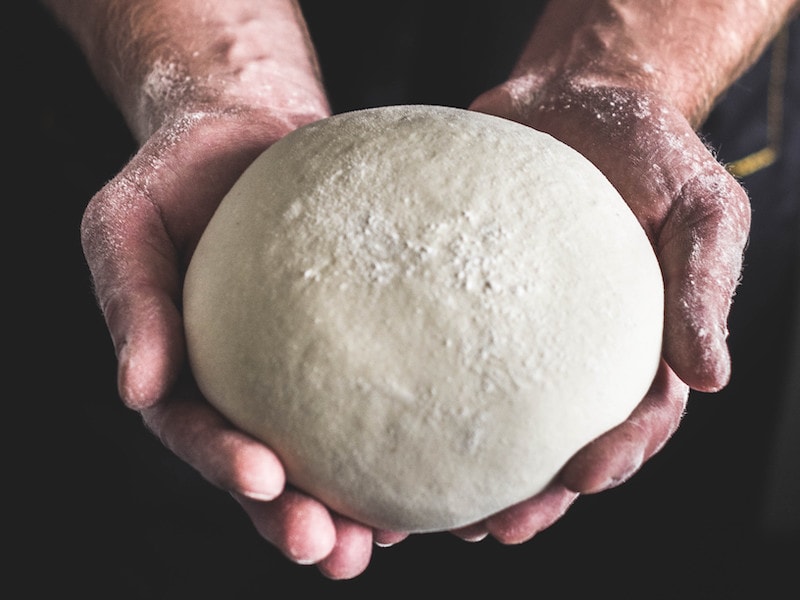 Hands holding raw dough